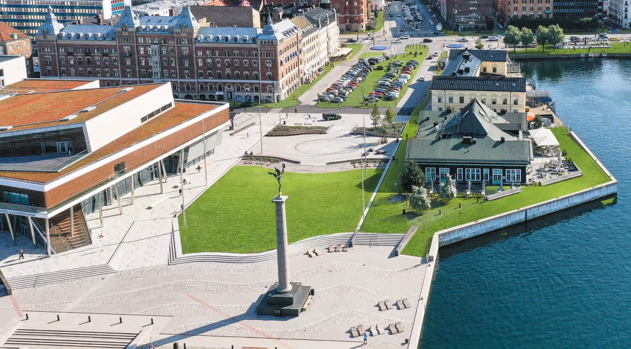 An aerial photograph of a waterfront square and buildings